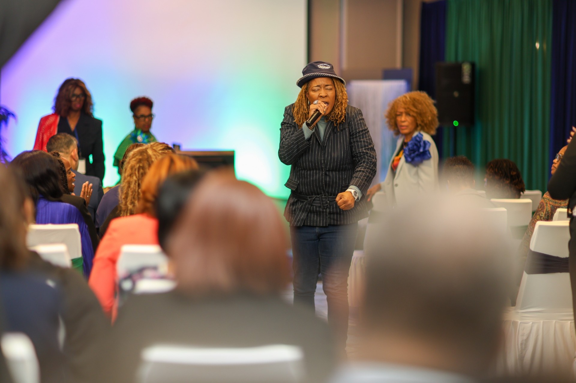 Dr. Ursula T. Wright speaking with a microphone while moving through the audience at a leadership conference