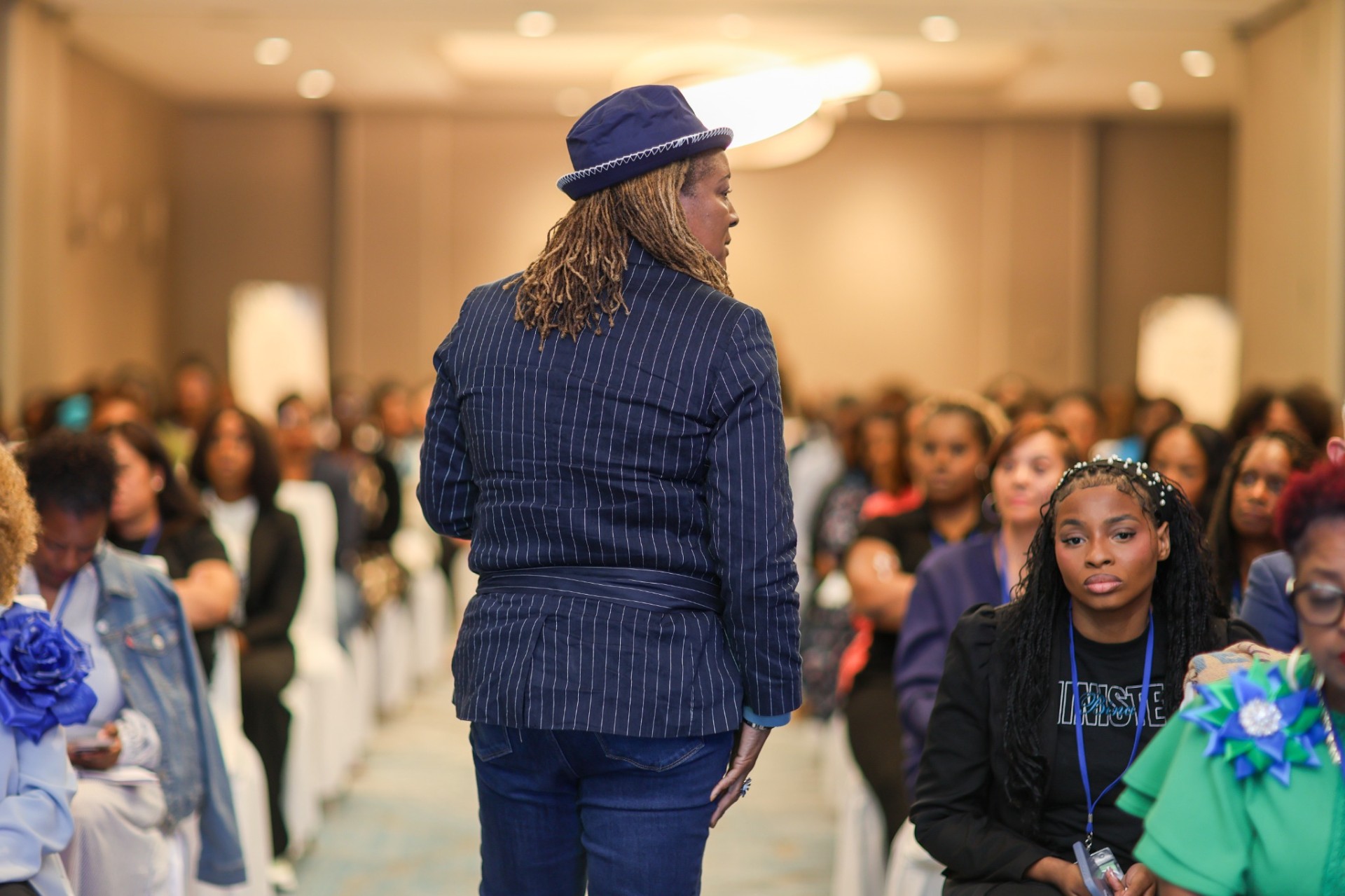 Dr. Ursula T. Wright standing in the aisle addressing a full room of attendees